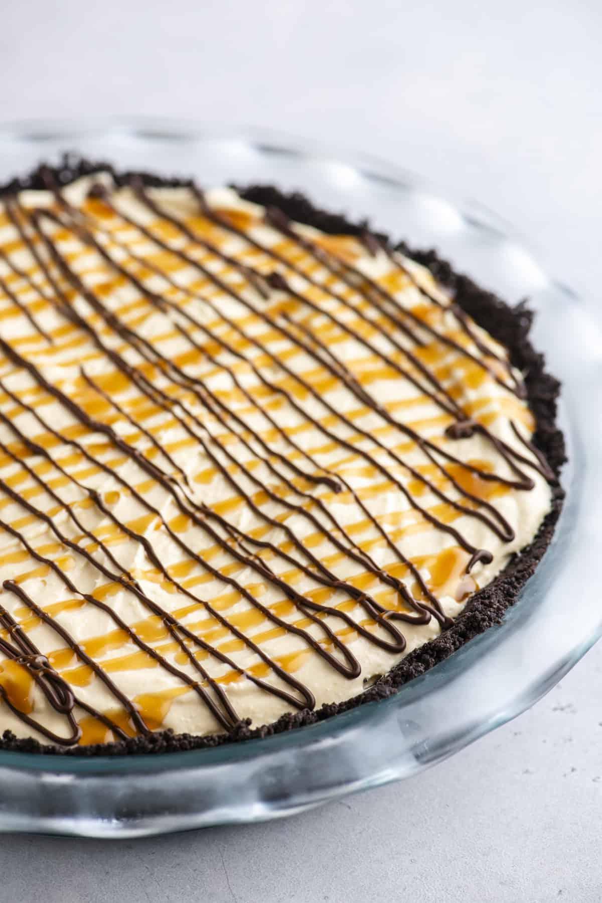 Torta di Tartaruga 7 Torta Tartaruga guarnita con gocce di cioccolato e caramello in un piatto trasparente.