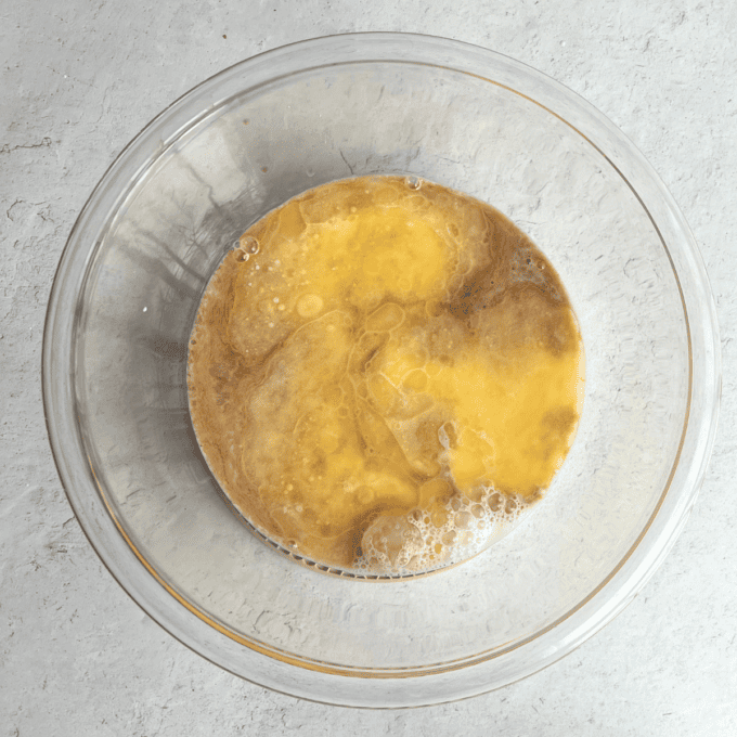 Pancakes Soffici Fatti in Casa 7 Una ciotola di vetro trasparente con gli ingredienti liquidi per i pancake.