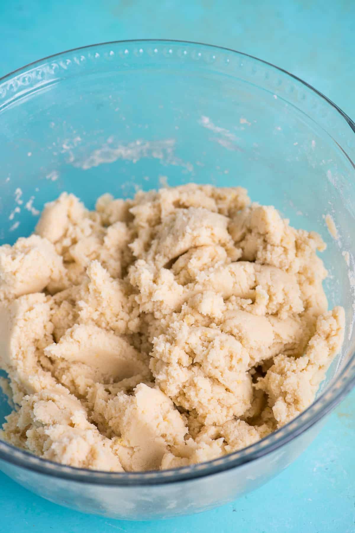 Ricetta Biscotti al Limone 7 Impasto per biscotti in una ciotola di vetro su sfondo blu