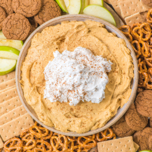 **Mousse di Zucca** 8 Una ciotola di cremosa crema di zucca con panna montata e cannella, circondata da fette di mela verde, pretzel, cracker Graham e biscotti allo zenzero.