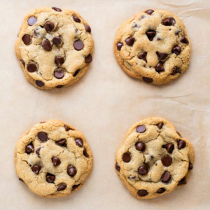 **Ricetta di Biscotti con Gocce di Cioccolato in Piccola Quantità** 2 Visuale dall'alto di 4 biscotti con gocce di cioccolato su carta forno