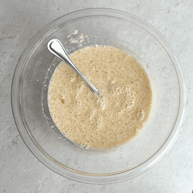 Pancakes Soffici Fatti in Casa 8 Ingredienti liquidi per i pancake in una ciotola di vetro trasparente con una forchetta.