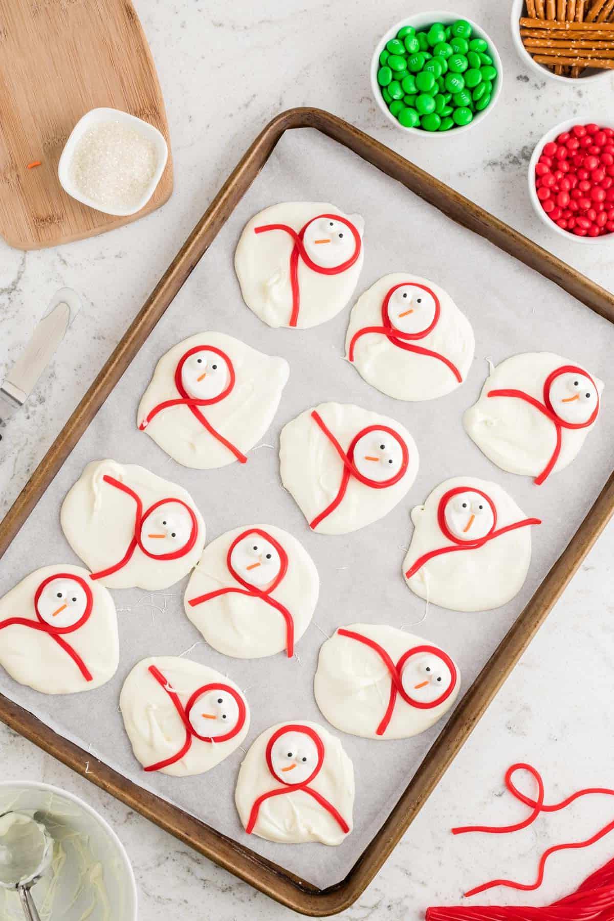 gocce di cioccolato bianco fuso con facce di pupazzo di neve