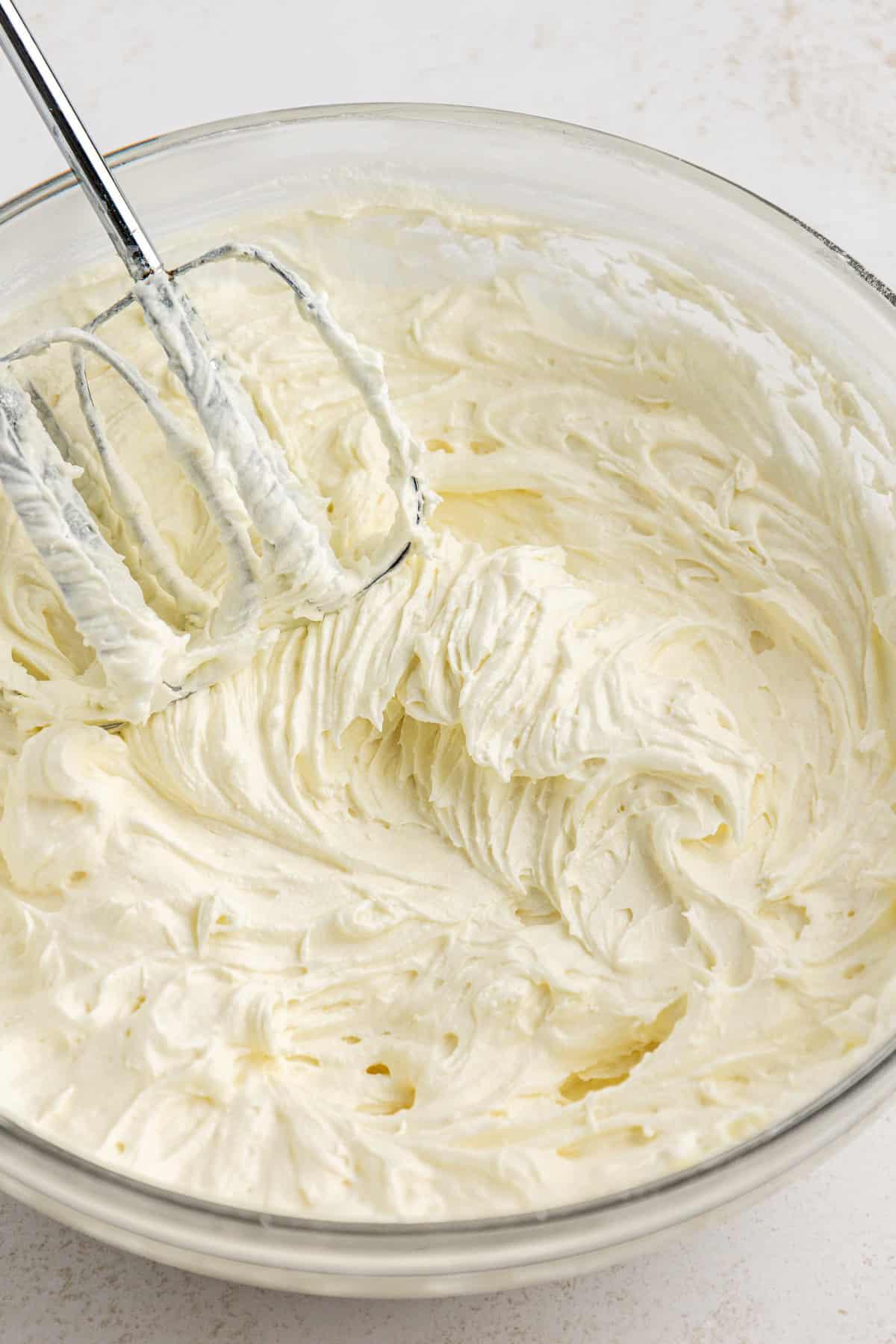 La migliore ricetta per la Torta al Fango 8 Crema di formaggio, burro e zucchero a velo mescolati in una ciotola di vetro trasparente con un mixer elettrico