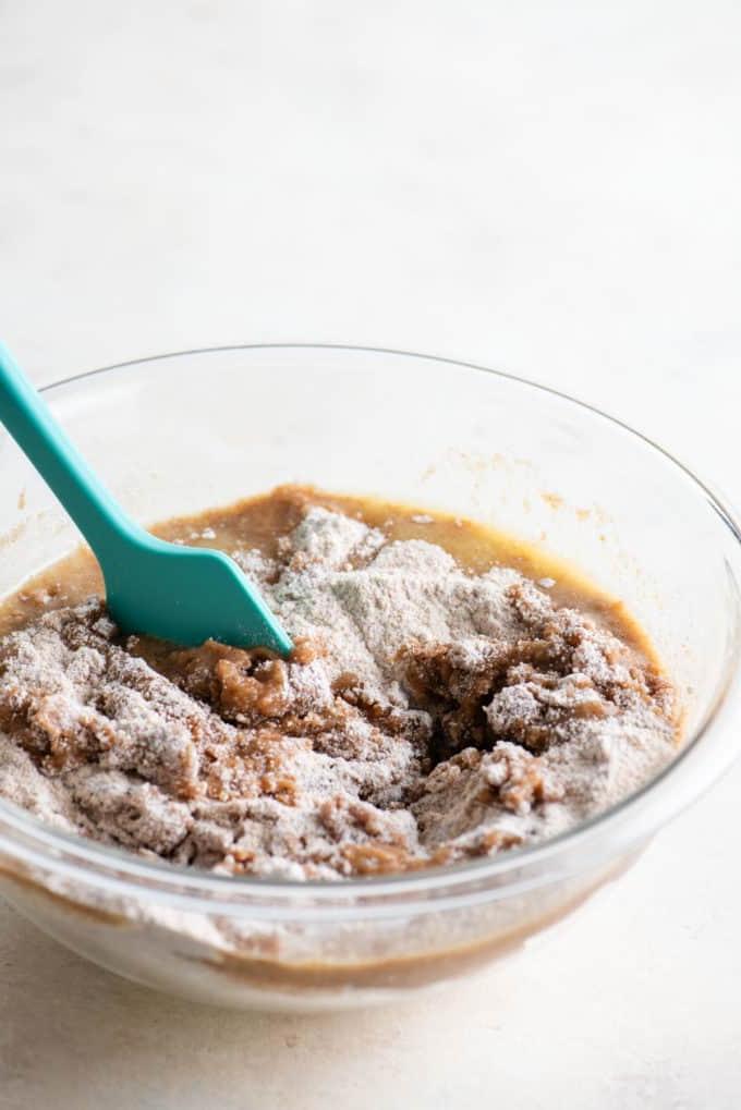 Ricetta Torta Umida al Caffè 8 Ingredienti per la copertura di crumble della torta al caffè mescolati in una ciotola di vetro trasparente con una spatola verde acqua