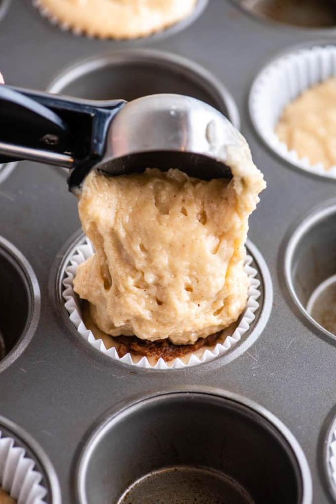 Muffin alla Sbriciolata 9 aggiunta di una paletta di impasto in una teglia da muffin