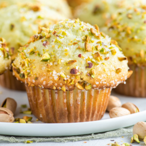 Muffin al Pistacchio 9 Pistachio muffins surrounded by whole pistachios in shells.
