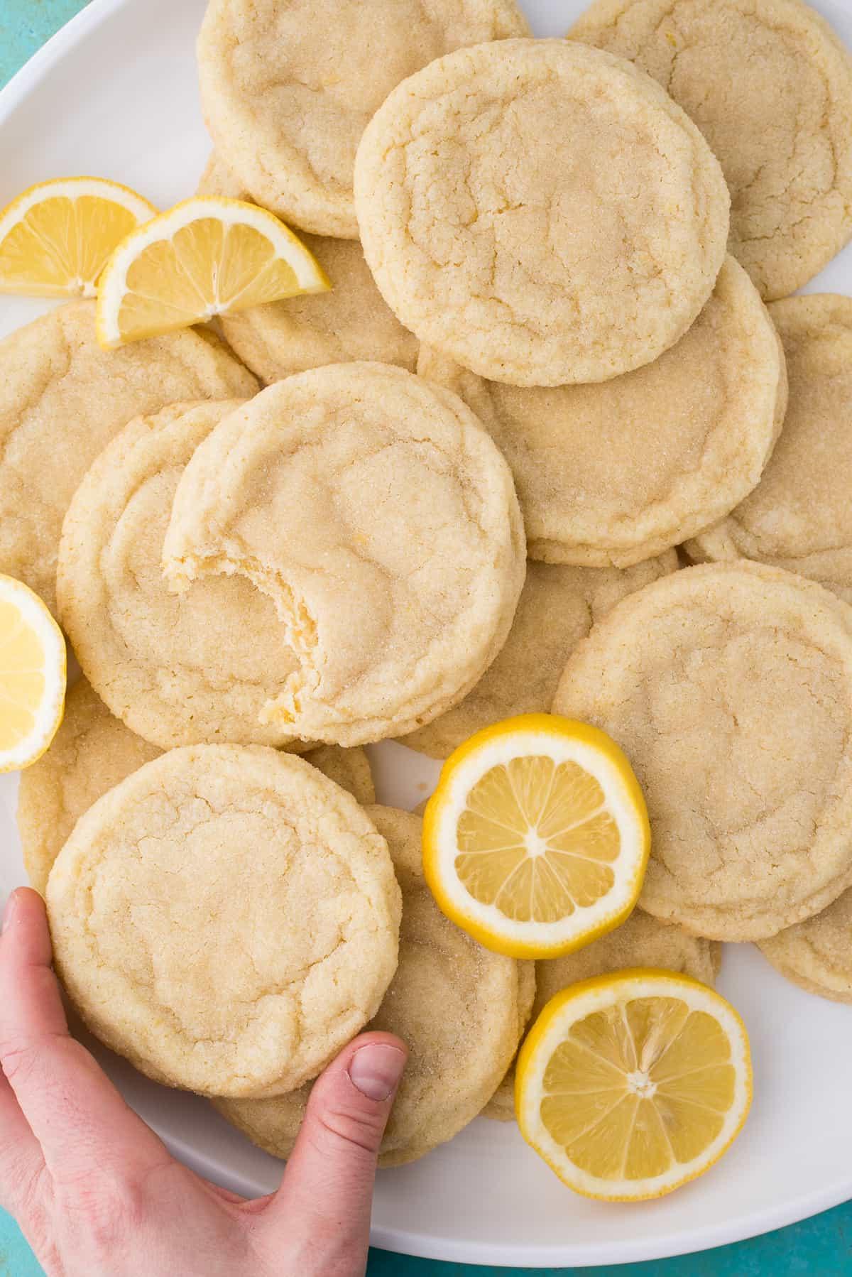 Ricetta Biscotti al Limone 9 Biscotti al limone con fette di limone su piatto bianco su sfondo blu