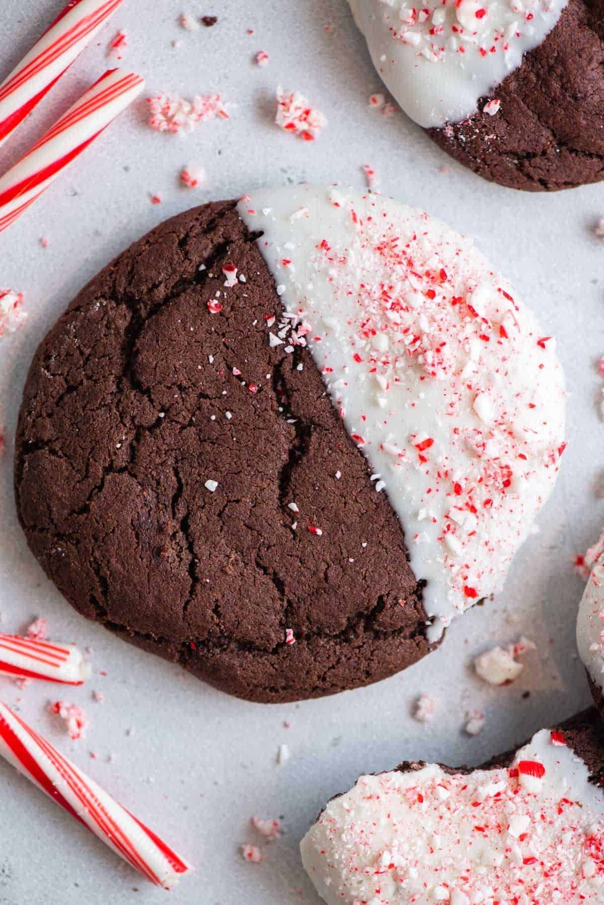 Questi Biscotti al Cioccolato e Bastoncini di Zucchero sono morbidi, gommosi, immersi nel cioccolato bianco e cosparsi di bastoncini di zucchero tritati. Vista dall'alto di un biscotto al cioccolato e bastoncini di zucchero