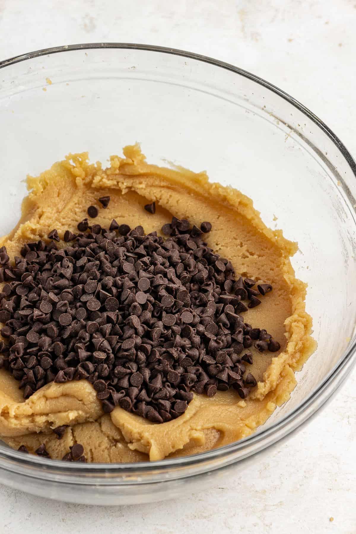 **Semplice Impasto per Biscotti Commestibile** 9 edible cookie dough in a clear glass bowl with a pile of chocolate chips on top