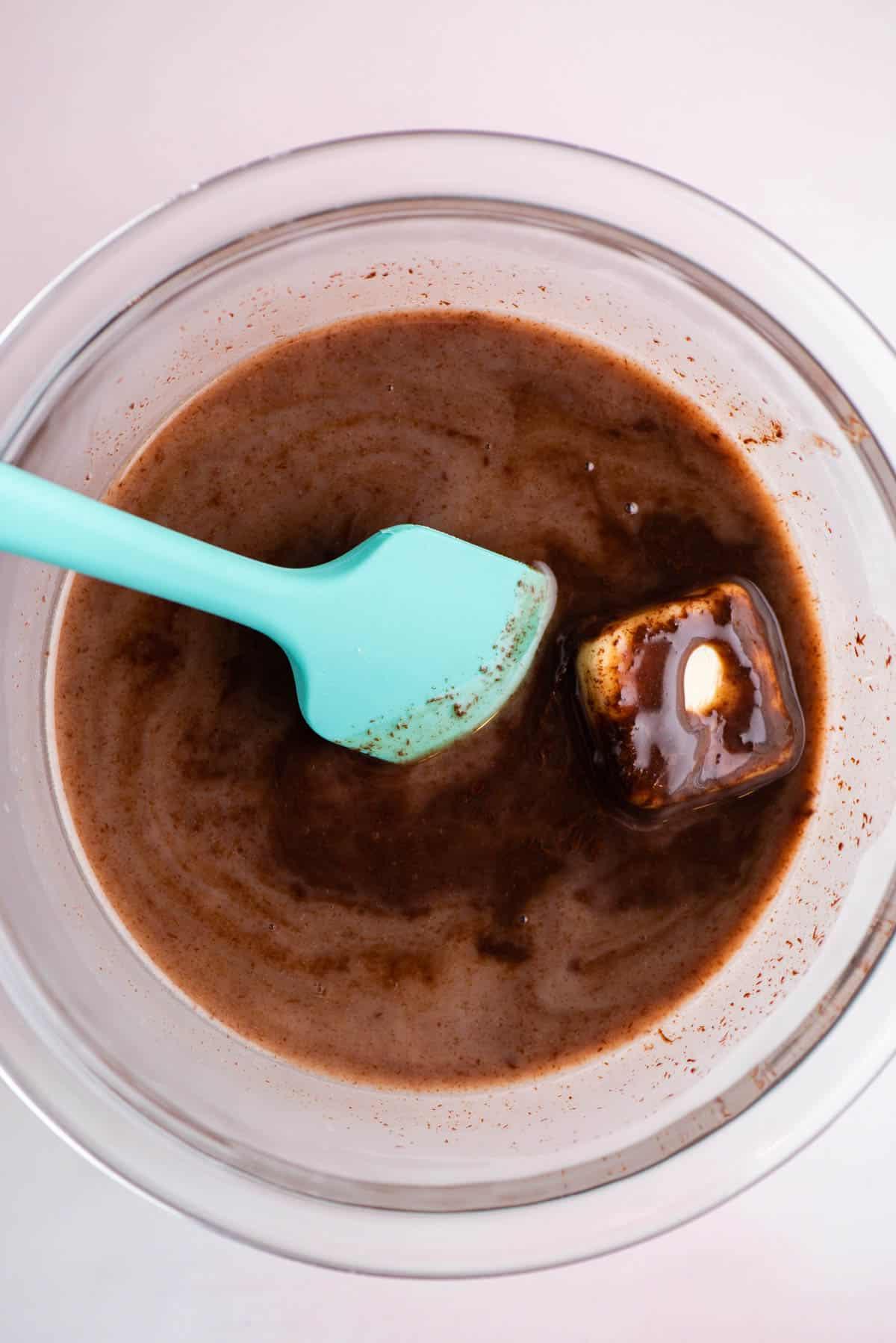 **Salsa Calda al Cioccolato Fondente** 10 Salsa hot fudge fatta in una ciotola di vetro mescolando il burro con il resto degli ingredienti usando una spatola color verde acqua