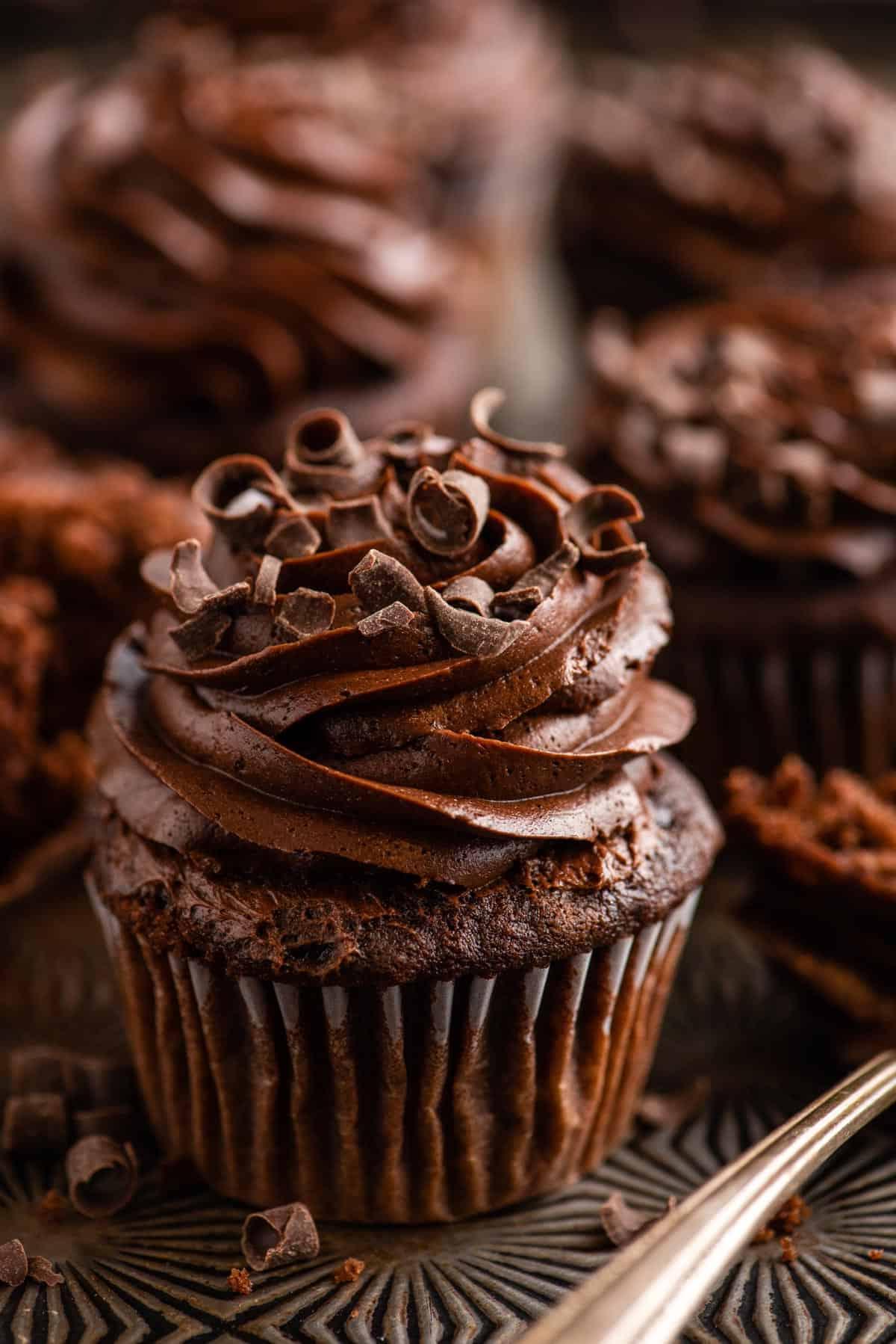 Cupcakes al cioccolato 2 Cupcake al cioccolato con glassa al cioccolato su sfondo metallico con altri cupcake in lontananza