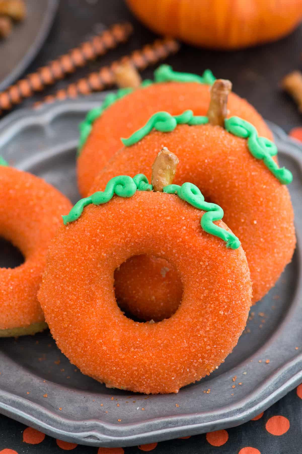 Ciambelle alla Zucca 2 Ciambelle di zucca al forno a forma di zucca, con glassa arancione e gambo di pretzel, perfette per l'autunno