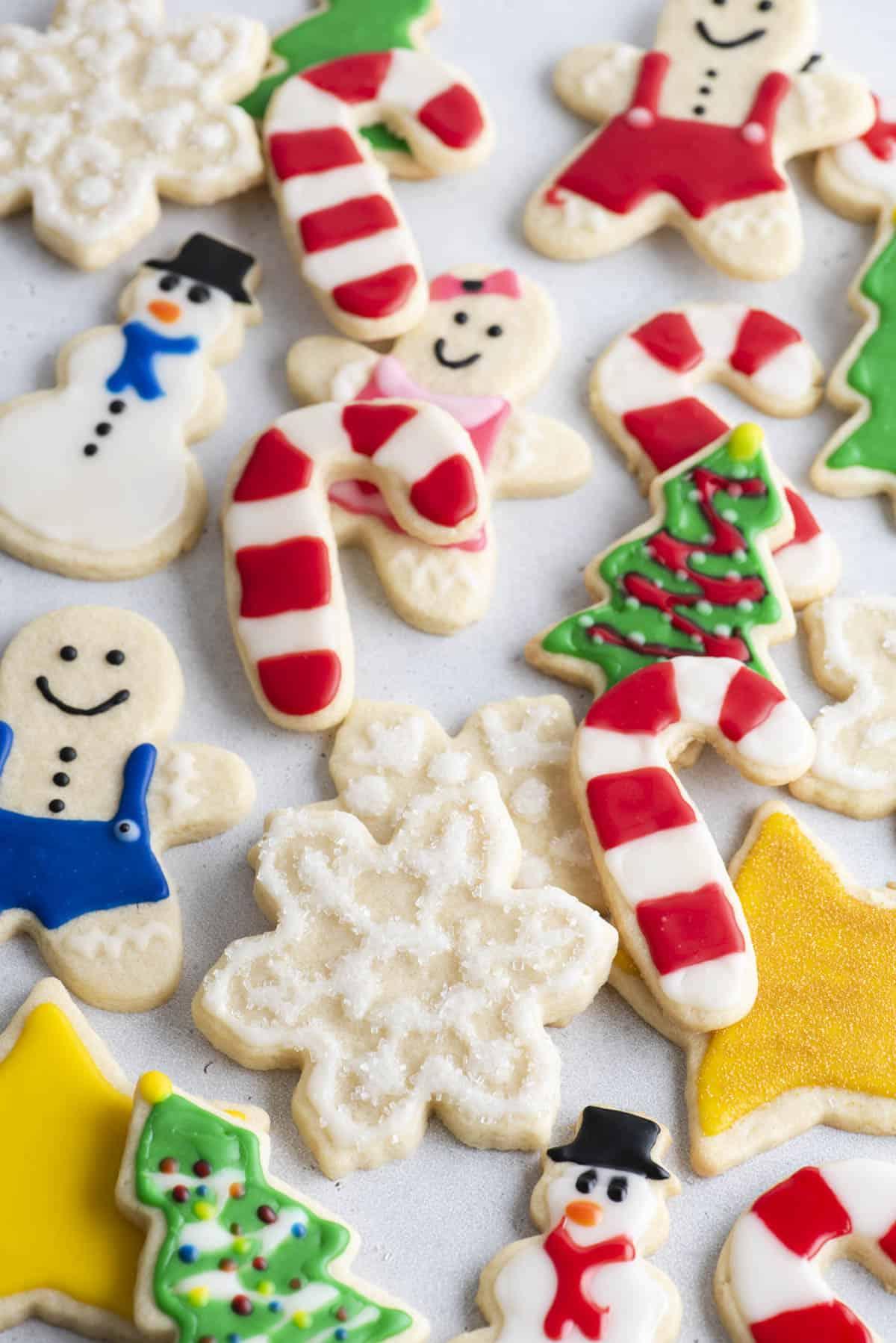 Glassa Reale senza Polvere di Meringa 2 un assortimento di biscotti natalizi decorati con ghiaccia reale sparsi intorno, inclusi bastoncini di zucchero, alberi di Natale, pupazzi di neve e fiocchi di neve