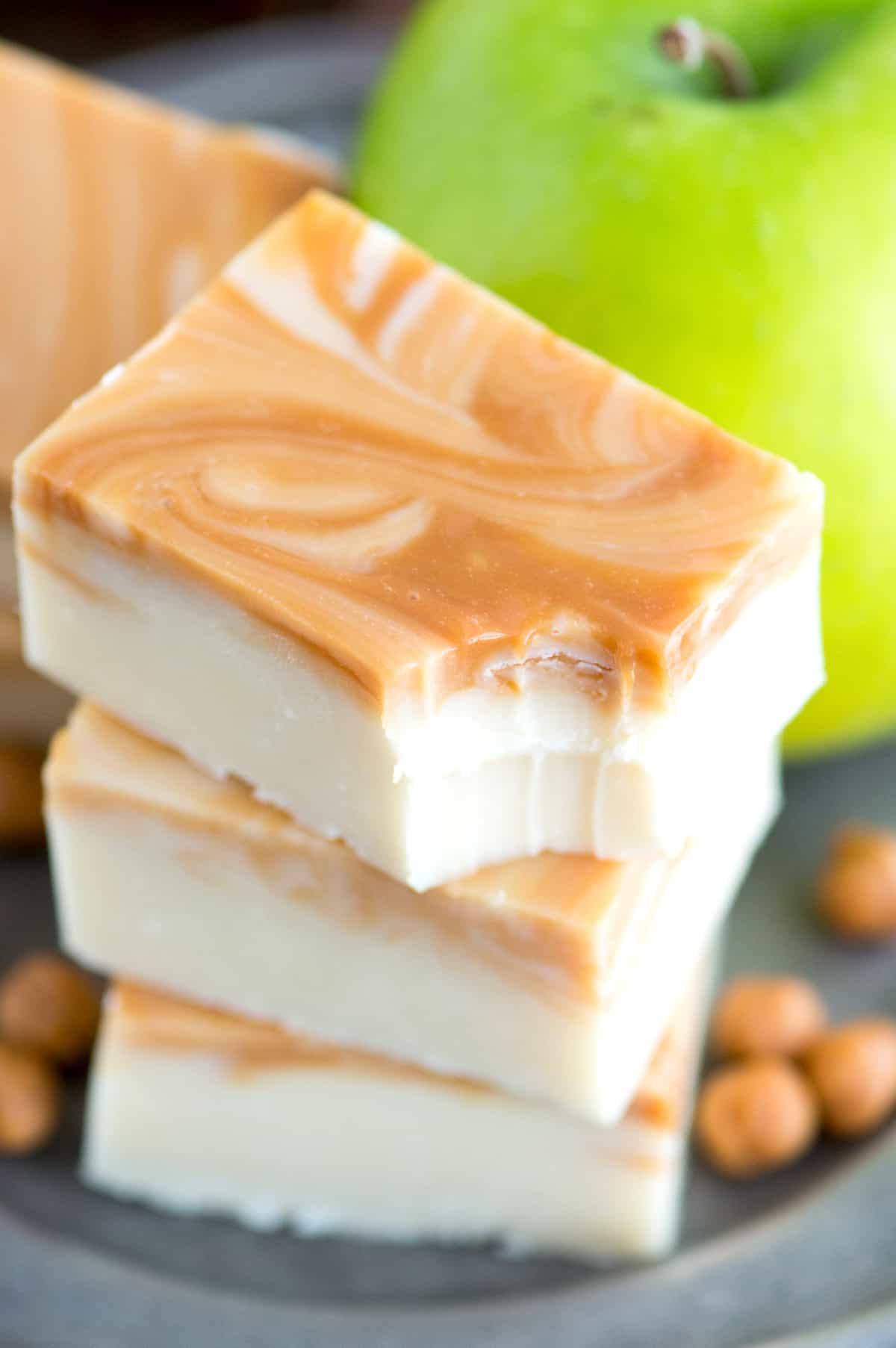 Si può congelare il fudge? 11 caramel apple fudge slices in a stack with bite removed from top fudge piece