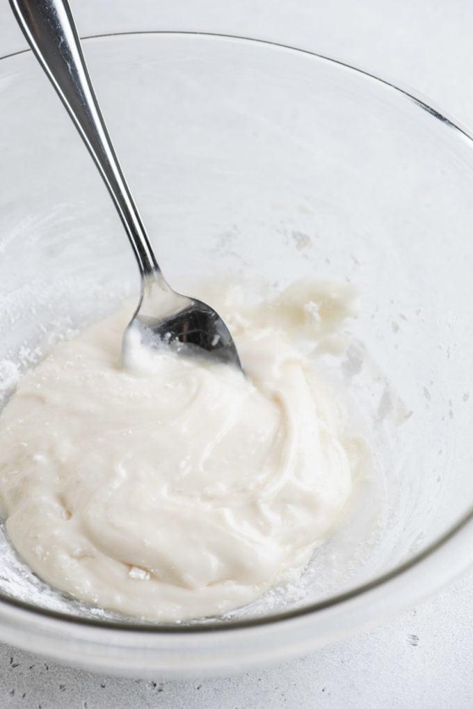 Glassa Reale senza Polvere di Meringa 12 ghiaccia reale in una ciotola di vetro trasparente con un cucchiaio