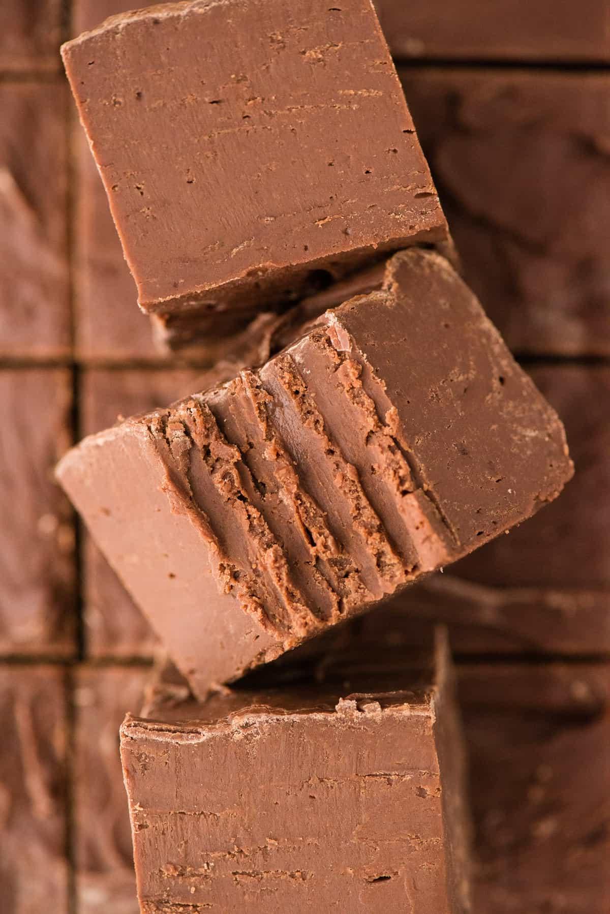Si può congelare il fudge? 14 3 pieces of chocolate fudge cut into squares with the center piece has a bite removed