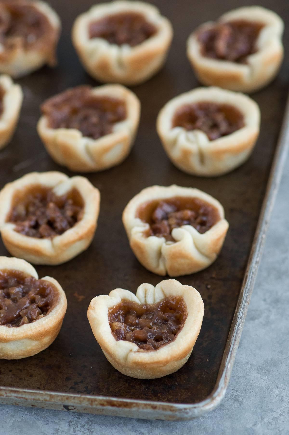 **Mini Bocconcini di Torta alle Noci Pecan e Cioccolato Vellutato** 3 Mini tortine noci pecan e cioccolato silk disposte elegantemente, pronte per essere gustate.