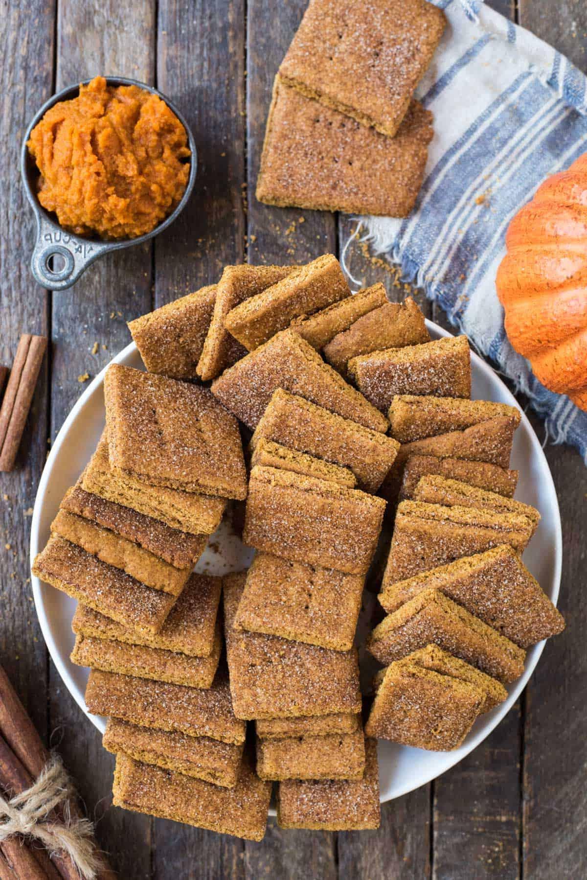 Biscotti Graham alla Zucca 3 Biscotti Graham alla zucca in un mucchio in una grande ciotola bianca su uno sfondo di legno