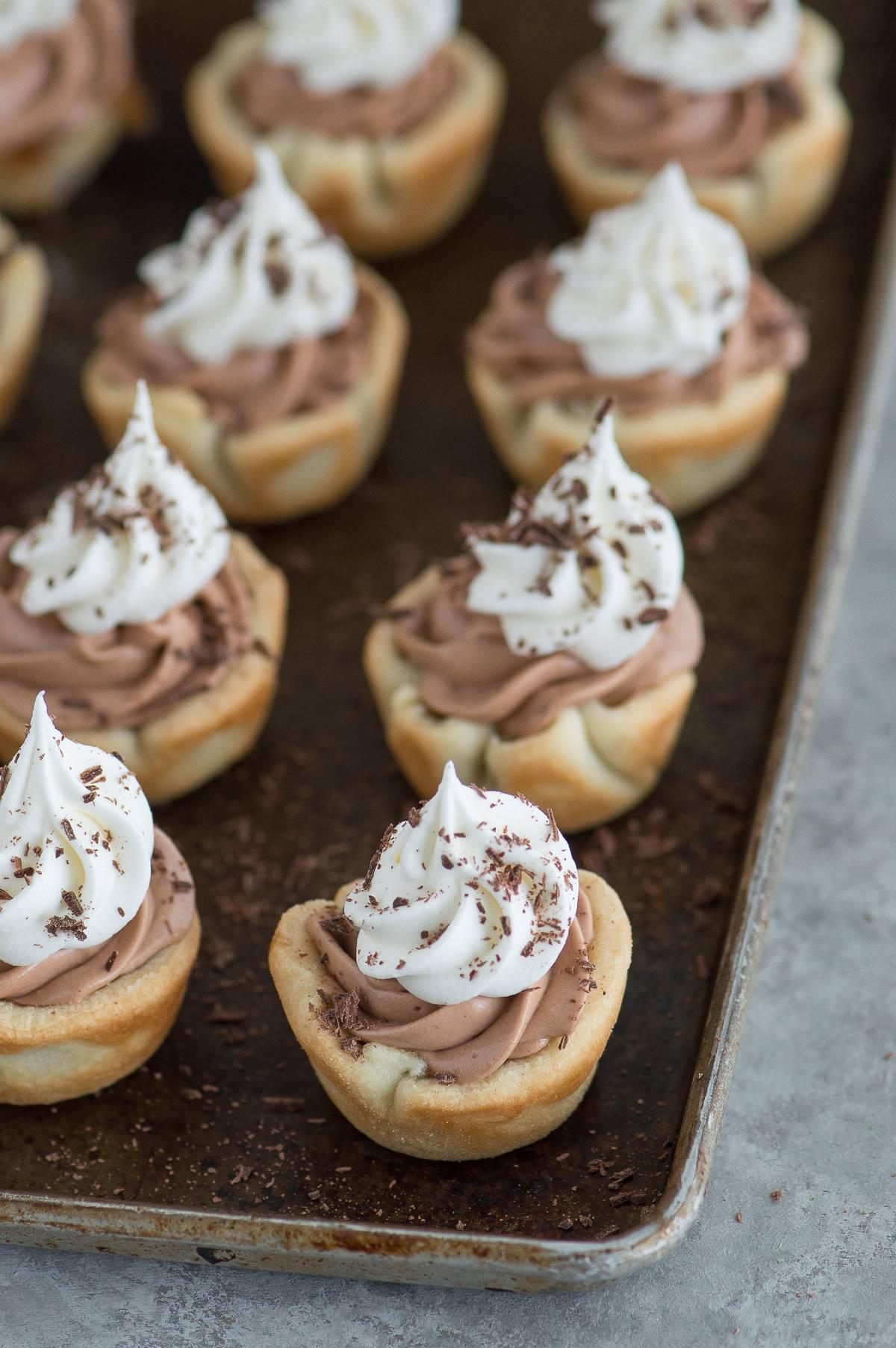 **Mini Bocconcini di Torta alle Noci Pecan e Cioccolato Vellutato** 4 Mini tortine noci pecan e cioccolato silk con decorazioni raffinate, pronte da servire.