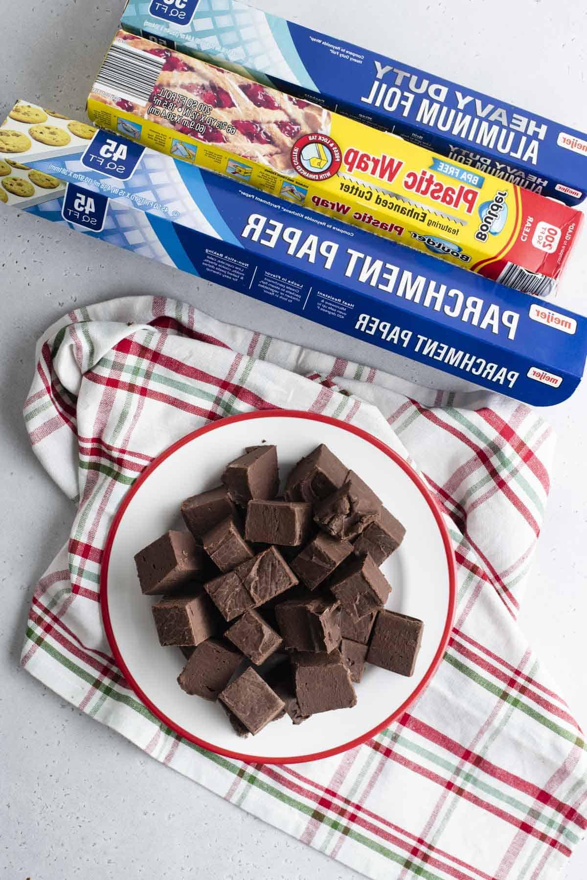 Si può congelare il fudge? 5 aluminum foil, plastic wrap, parchment paper boxes and plate of chocolate fudge