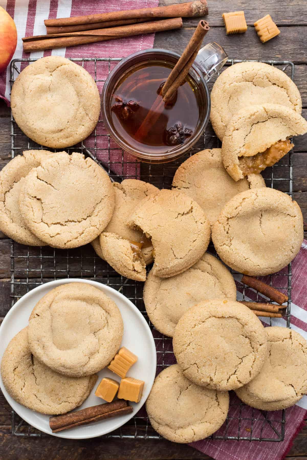 Biscotti alle Mele e al Caramello 5 cookies arranged randomly on metal baking rack on wood background