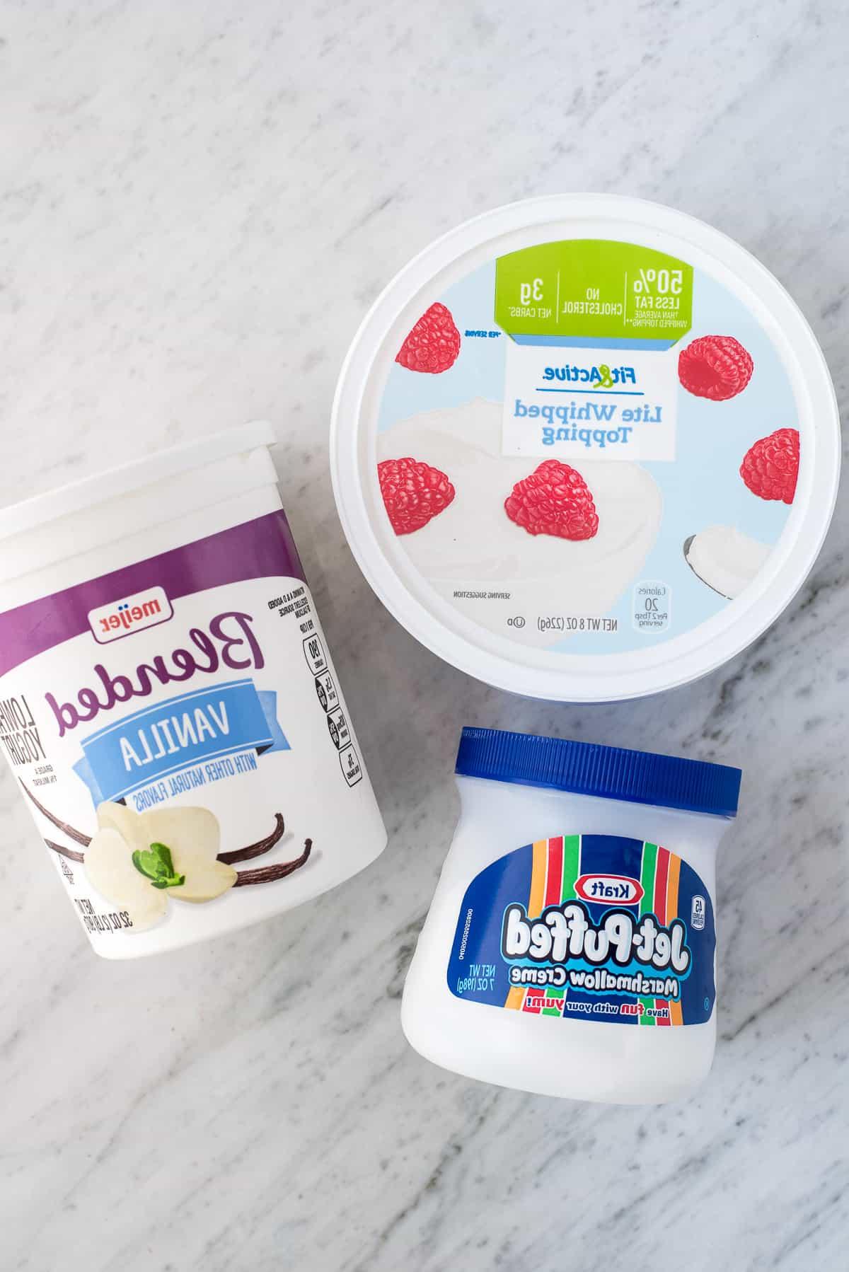 Dip alla frutta con 3 ingredienti! Amiamo questa crema vellutata perché NON c'è formaggio spalmabile! Piatto rotondo pieno di fragole, mele, more, lamponi e uva con una ciotola di dip bianco per frutta al centro