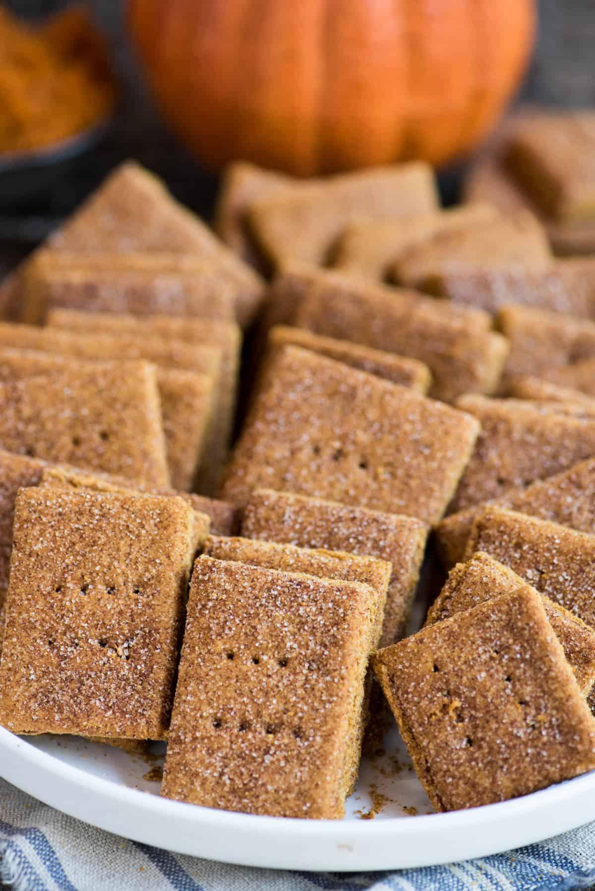Biscotti Graham alla Zucca 6 Biscotti Graham alla zucca in un mucchio in una grande ciotola bianca su uno sfondo di legno