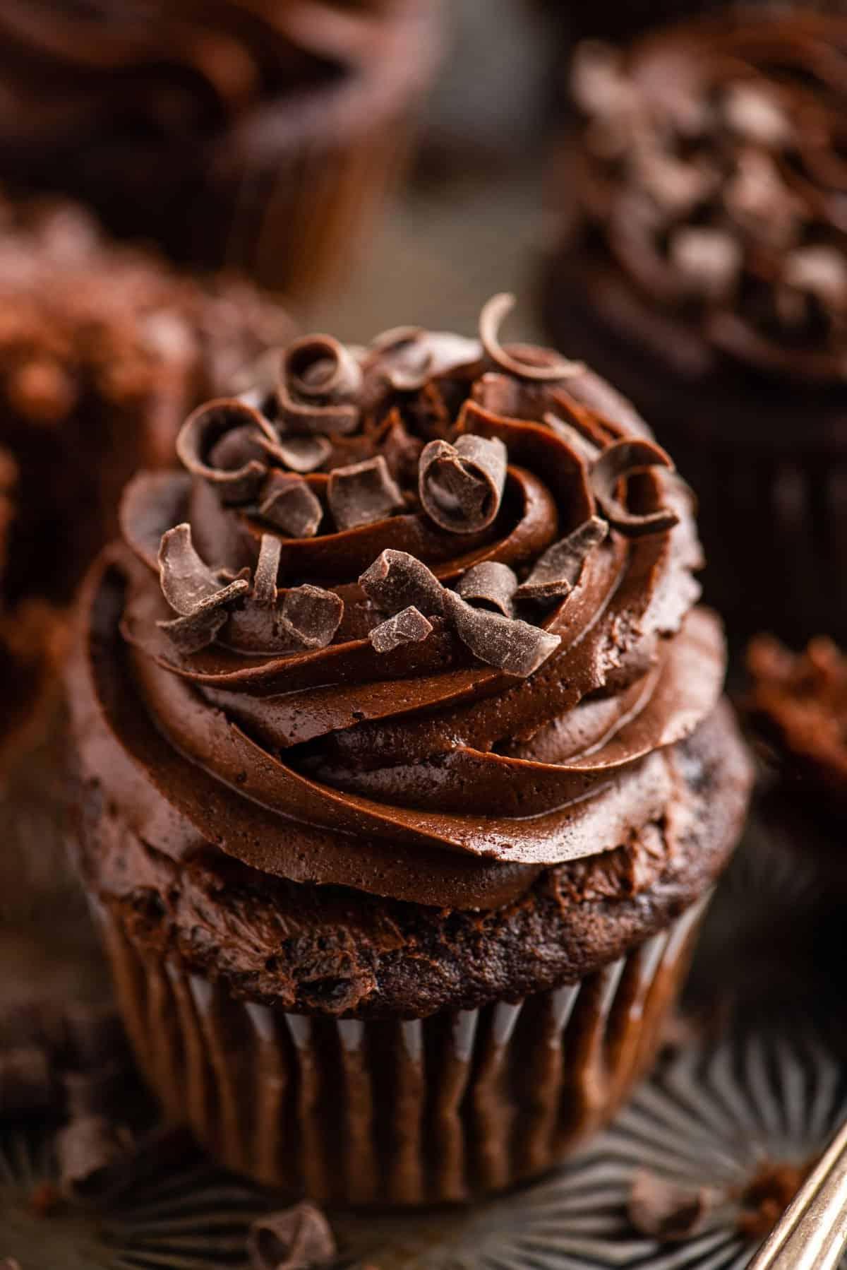 Cupcakes al cioccolato 7 Cupcake al cioccolato con glassa al cioccolato su sfondo metallico con più cupcake in lontananza