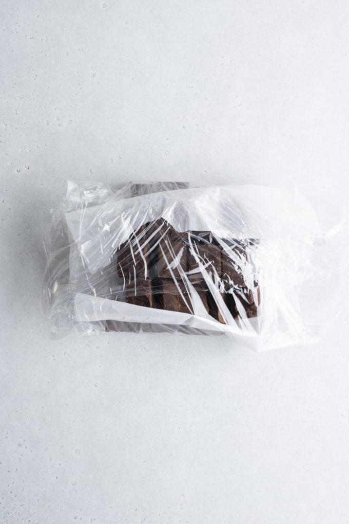 Si può congelare il fudge? 7 chocolate fudge with parchment paper between layers wrapped in plastic wrap