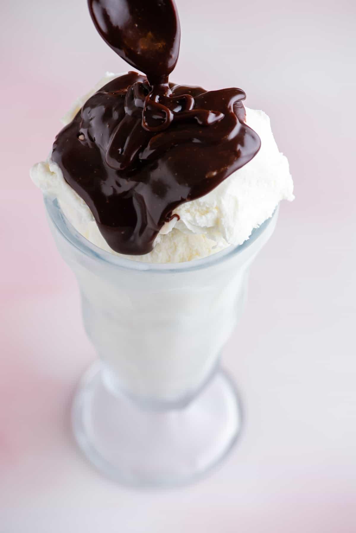 Hot Fudge Sundae 8 Un bicchiere alto pieno di gelato alla vaniglia ricoperto di salsa al cioccolato fuso