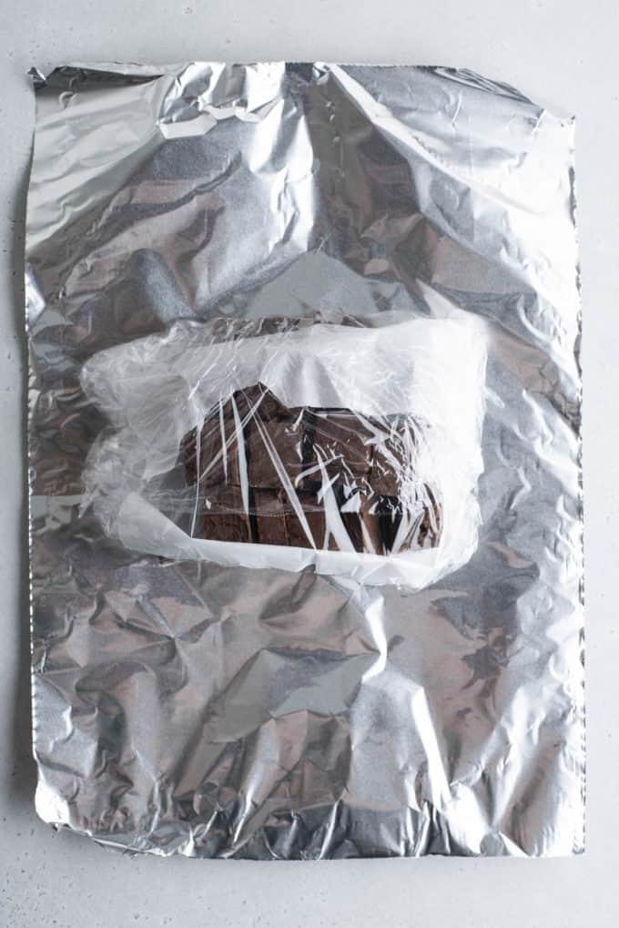 Si può congelare il fudge? 8 chocolate fudge wrapped in plastic wrap on top of aluminum foil