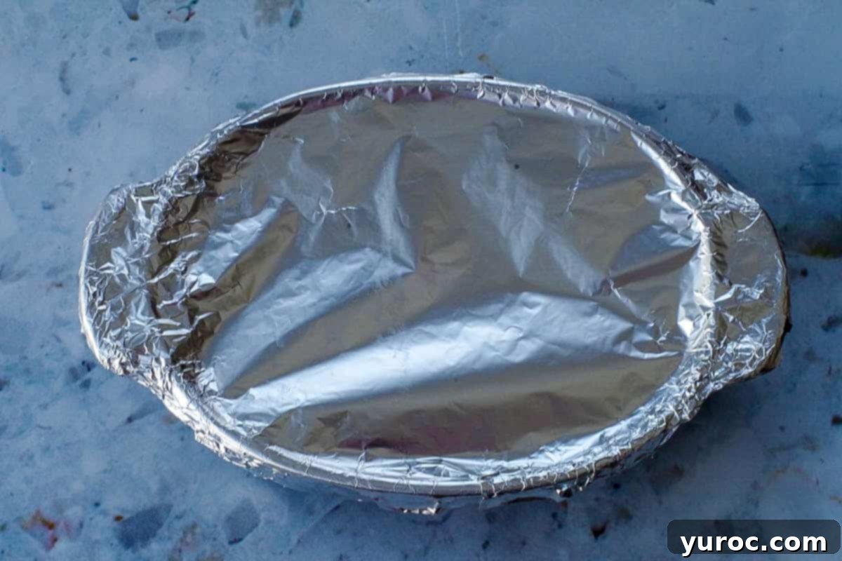 Casserole dish covered and sealed with aluminum foil.
