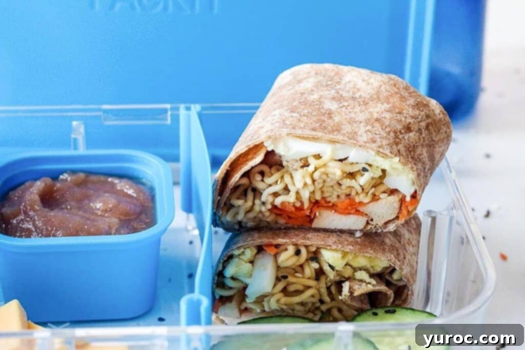 Ramen Roll 3 Ramen wrap stacked in a bento lunchbox beside a berry sauce