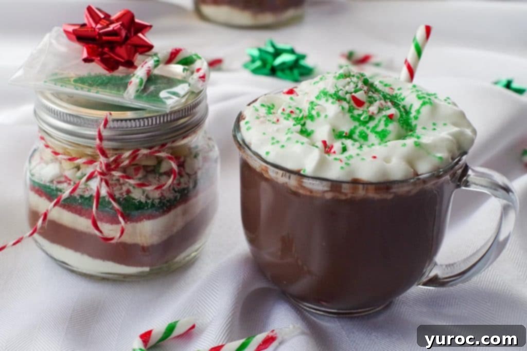 candy cane hot chocolate mix in a jar with a mug of hot chocolate beside it
