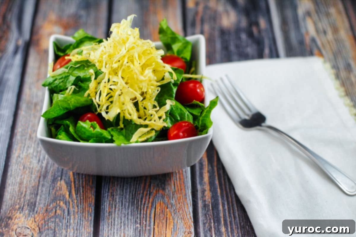 Parsnip ribbons elegantly arranged as a crispy topping on a fresh, vibrant green salad.