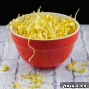 Golden brown parsnip crisps served in an orange bowl on a white surface, ready to be enjoyed.