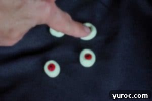 hand pushing in eyes on top of marshmallows