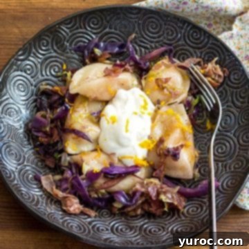 Potato Cheddar Vareniki on black plate with fork