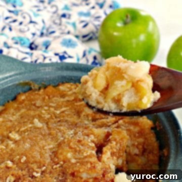 turnip and apple casserole (weight watchers friendly in a blue casserole dish, being held up on a wooden spoon with a green apple and blue patterned oven mitt in the background