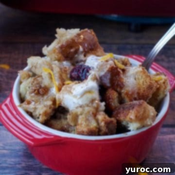 cranberry toffee bread pudding in a red bowl with a spoon
