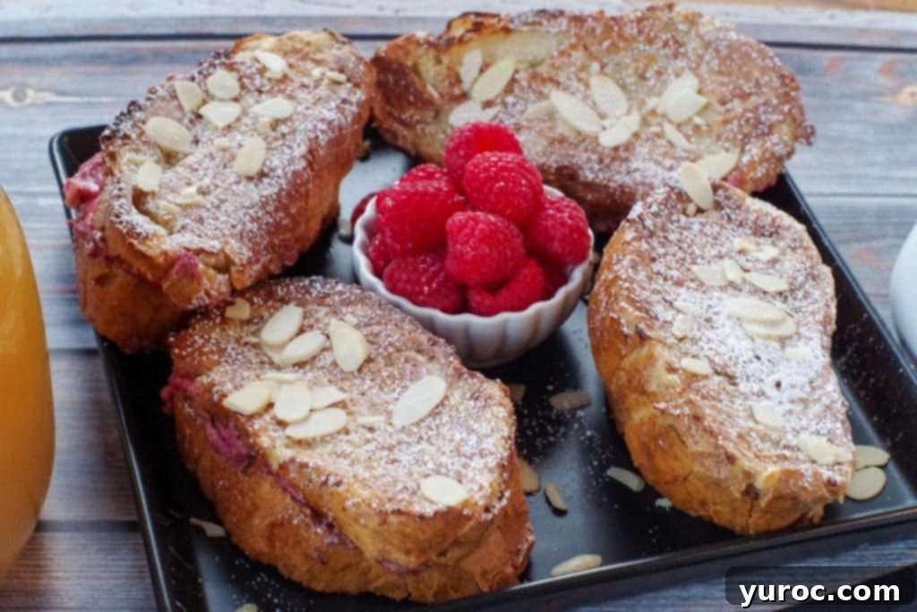 Raspberry Cream-Filled French Toast Sandwich 5 4 French Toast Sandwiches on a black platter with a white bowl of raspberries in the middle