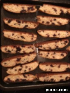 Sliced biscotti pieces laid flat on a baking sheet, ready for the second bake to achieve crispness.