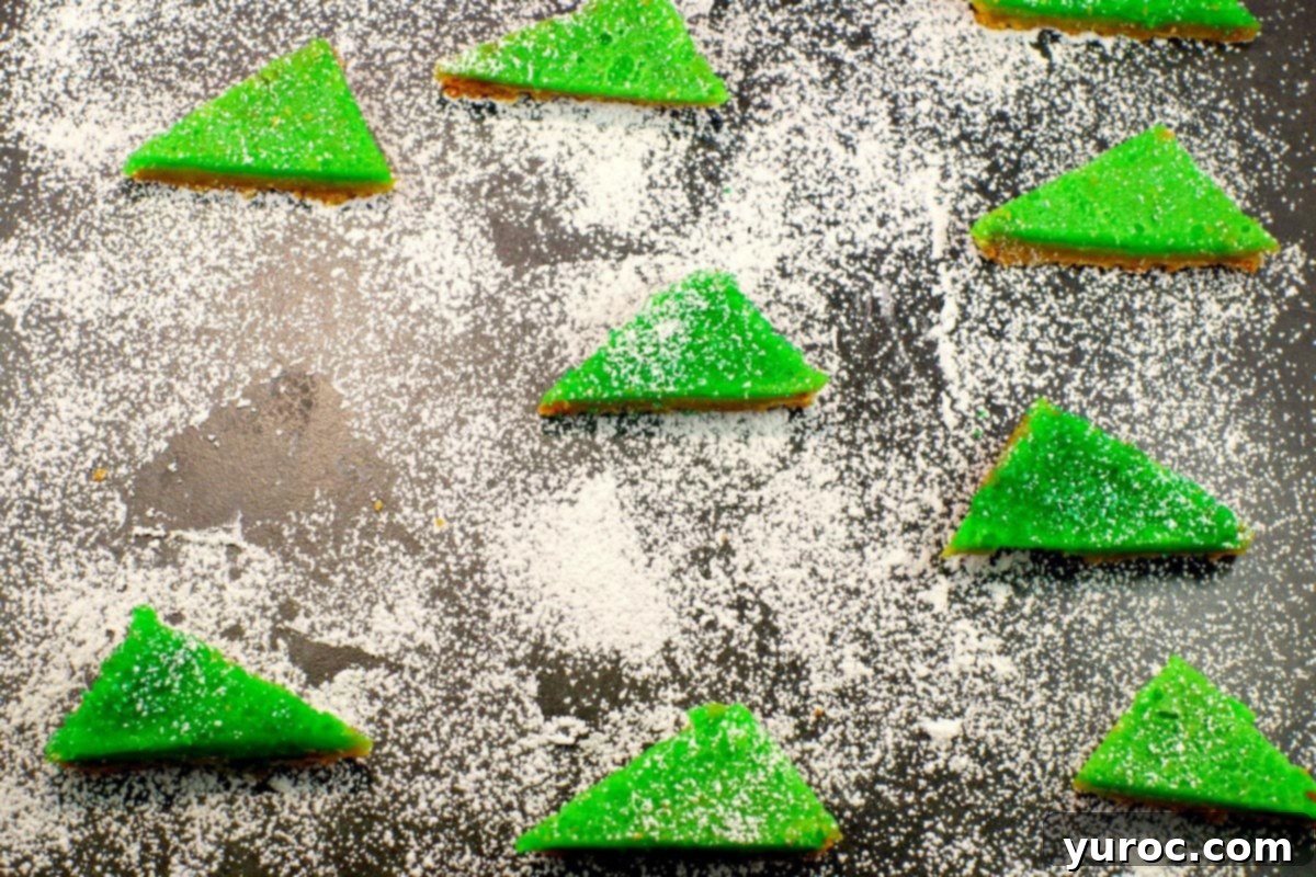 lime squares with powdered sugar on a cutting board with powdered sugar and space where one has been removed