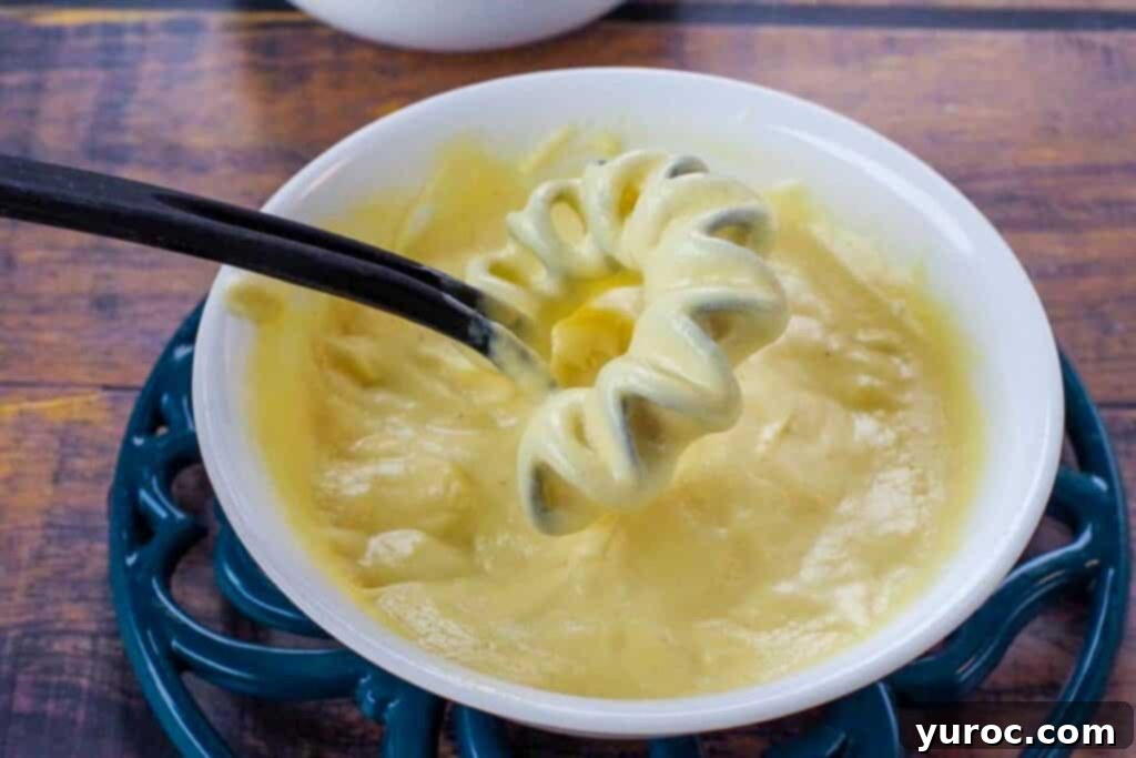Lighter Hollandaise 6 Hollandaise sauce in a white bowl with a whisk