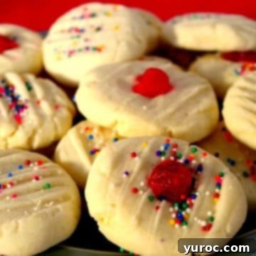 A delightful stack of four-ingredient whipped shortbread cookies piled high on a plate, set against a festive red background.