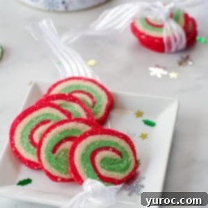 4 Christmas pinwheel cookies on a white plate with 3 cookies in a ribbon in the background
