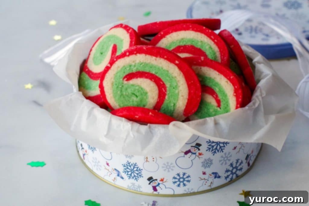 Pinwheel Christmas cookies in a white and blue snowflake patterned cookie tin