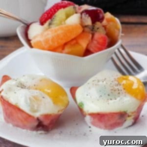 healthy eggs benedict on a white plate with a fork and a bowl of fruit