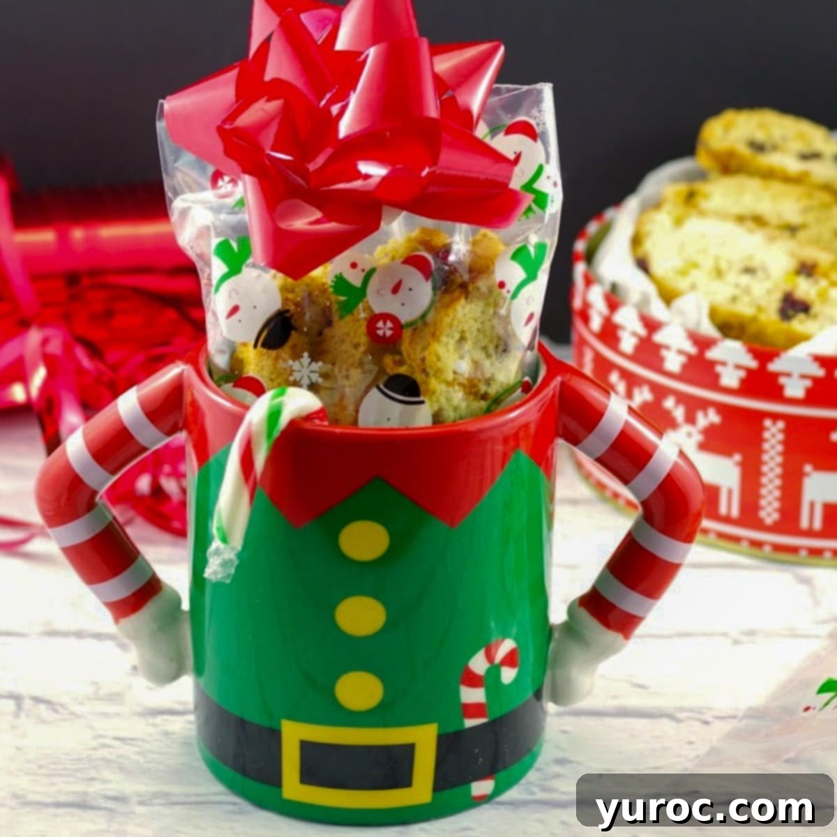 Christmas biscotti in a Christmas mug with a gift box of biscotti in the background